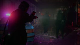 Alan Wake points his gun and flashlight in an Alan Wake 2 screenshot.