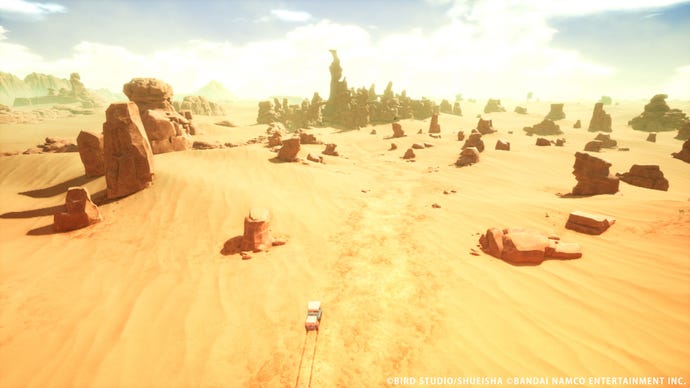 An aerial view of Sand Land's vast desert, as a jeep rolls along a dusty track.